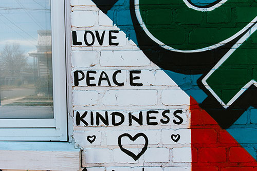 Part of a Giving Wall mural showing the words Love, Peace, and Kindness