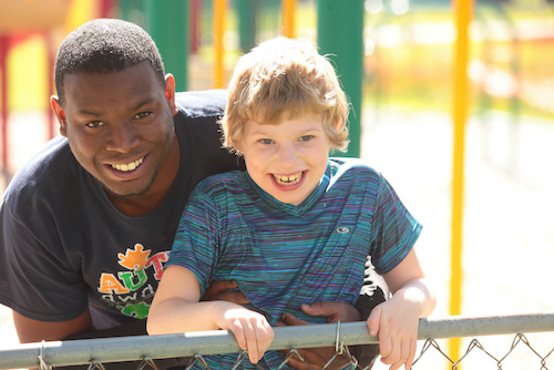 A man and boy smiling in a park