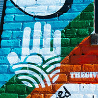 The Giving Wall logo painted on a mural